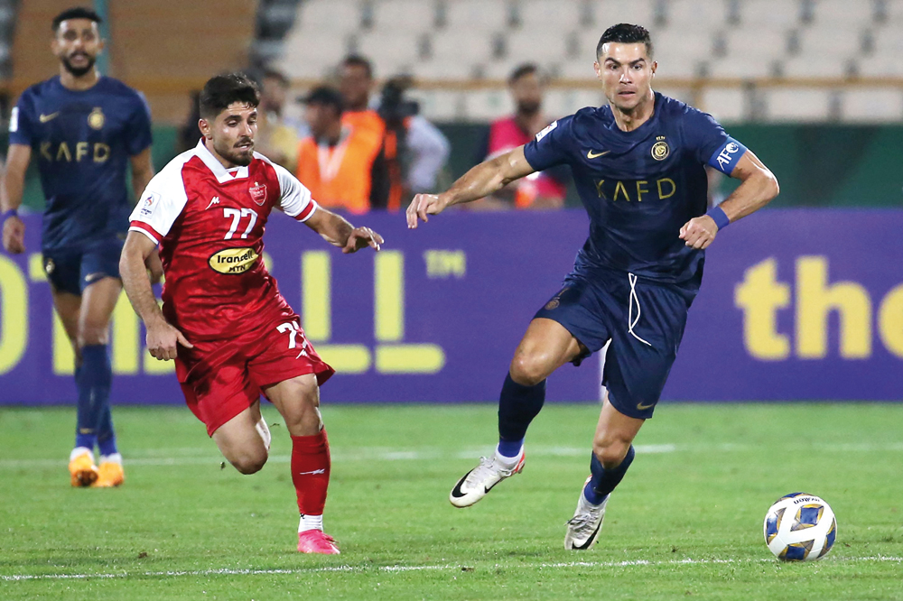 Al Nassr’s Cristiano Ronaldo (right) and Persepolis’ Mohammad Omri vie for the ball. AFP