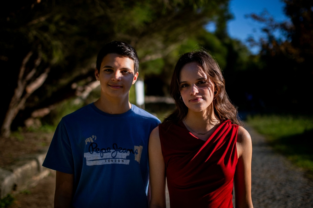 Sofia Oliveira, a 18-year-old citizen from the suburbs of Lisbon and her brother Andre, 15-year-old, two of six young people taking 32 countries to the European Court of Human Rights for their inaction on climate, pose for a photograph in Almada on August 10, 2023. (Photo by Carlos Costa / AFP)