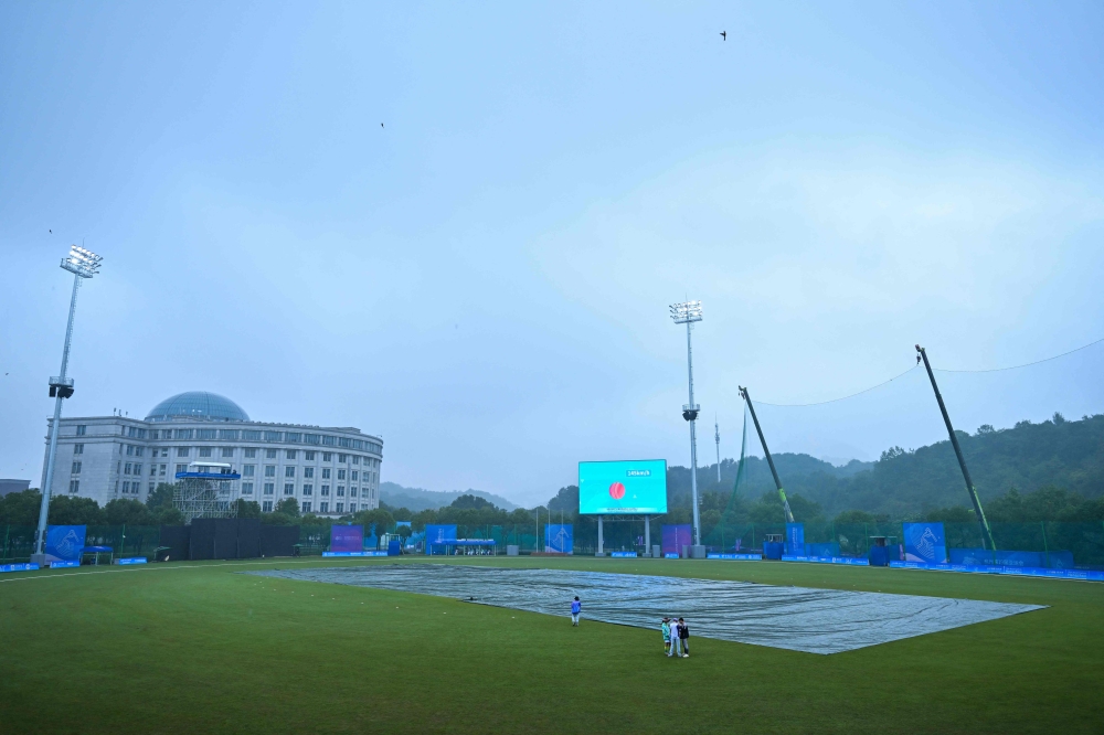 A general view shows covers on he field as rain delays the start of the 2022 Asian Games women's quarter-final cricket match between Bangladesh and Hong Kong in Hangzhou in China's eastern Zhejiang province on September 22, 2023. (Photo by Ishara S. KODIKARA / AFP)
