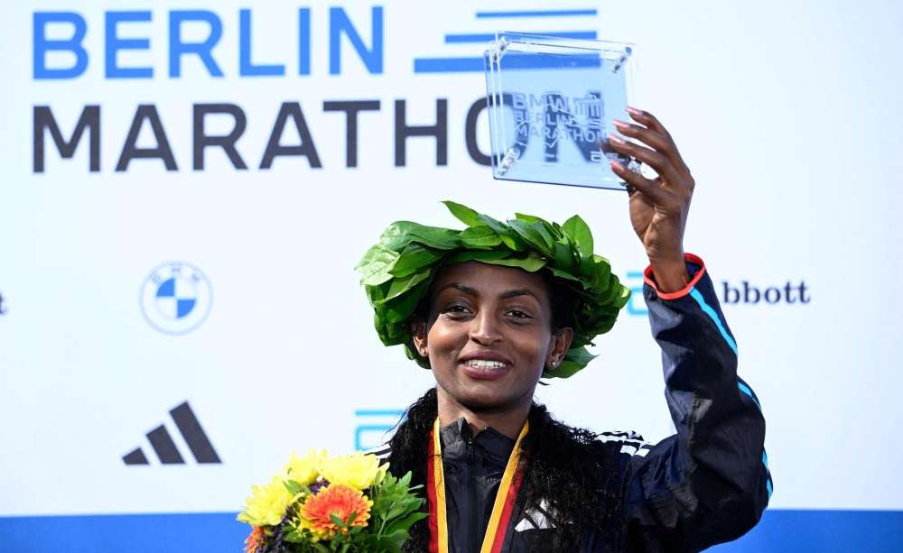 Ethiopia's Tigist Assefa celebrates on the podium with her trophy after winning the women's race of the Berlin Marathon on September 24, 2023 in Berlin, Germany.  (Photo by Tobias SCHWARZ / AFP)
