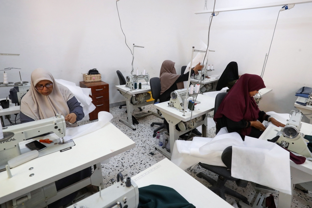 Participants work at a women's training and development center in Tripoli on September 23, 2023. (Photo by Mahmud Turkia / AFP)