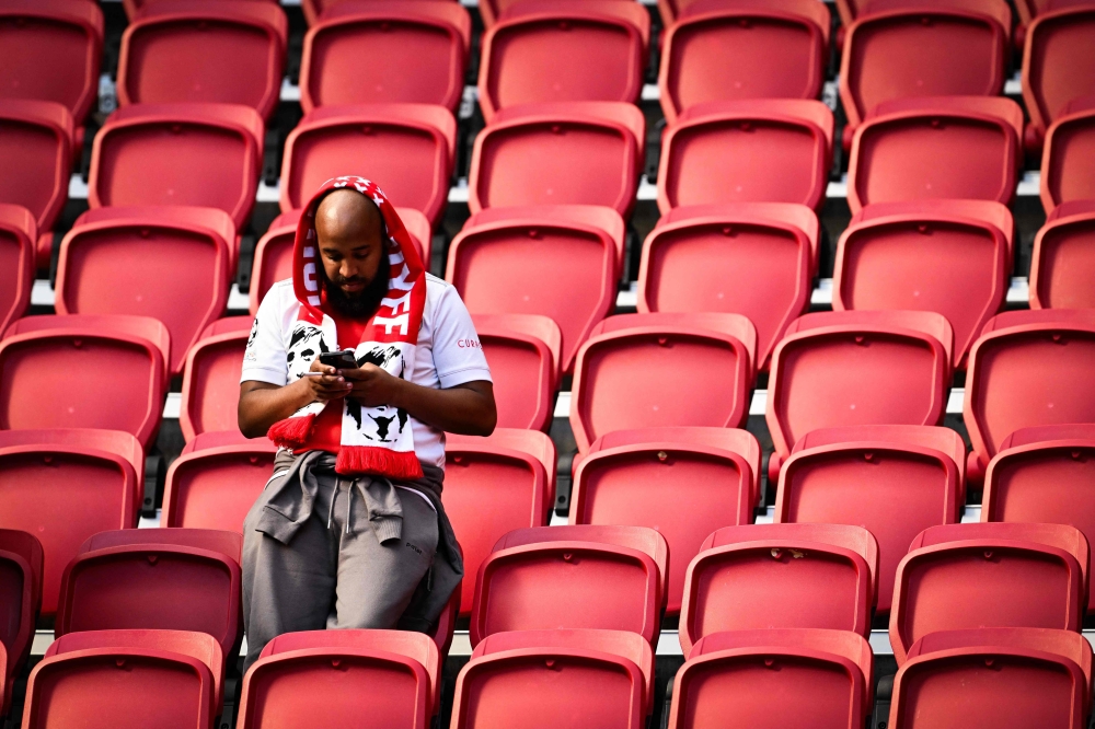 A supporter of Feyenoord checks his smartphone after the Dutch Eredivisie football match between Ajax Amsterdam and Feyenoord was ended following fireworks thrown on the field at the Johan Cruijff Arena in Amsterdam on September 24, 2023. (Photo by Olaf Kraak / ANP / AFP) / Netherlands OUT
