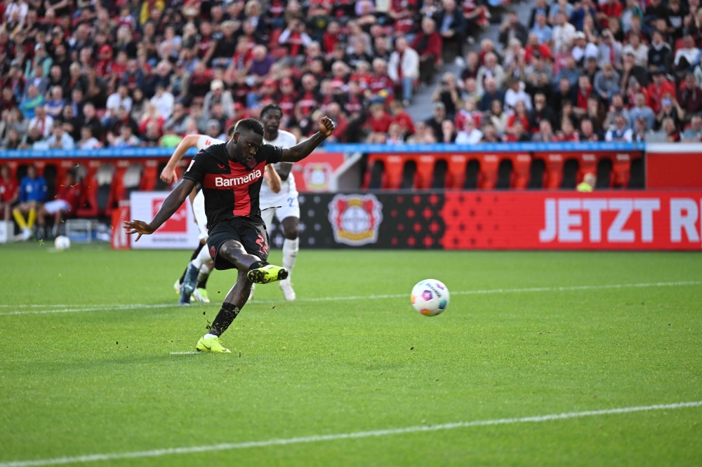 Bayer Leverkusen's Nigerian forward #22 Victor Boniface kicks the ball to score the 3-1 goal via penalty during the German first division Bundesliga football match between Bayer Leverkusen and FC Heidenheim in Leverkusen, western Germany, on September 24, 2023. (Photo by INA FASSBENDER / AFP)