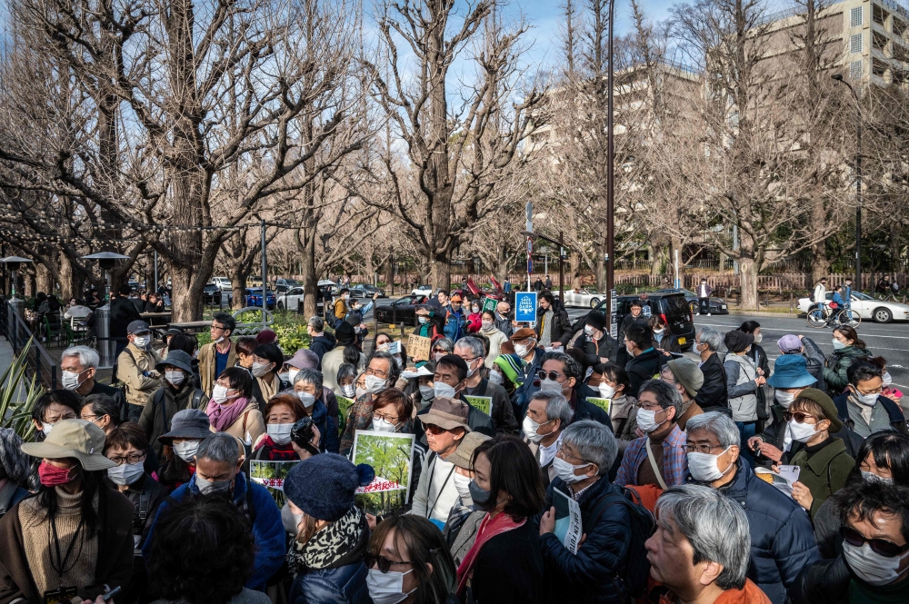 (Files) In this picture taken on February 12, 2023, people take part in a protest against the Tokyo metropolitan government's redevelopment project for the Meiji Jingu Gaien district in Tokyo.  (Photo by Yuichi Yamazaki / AFP)