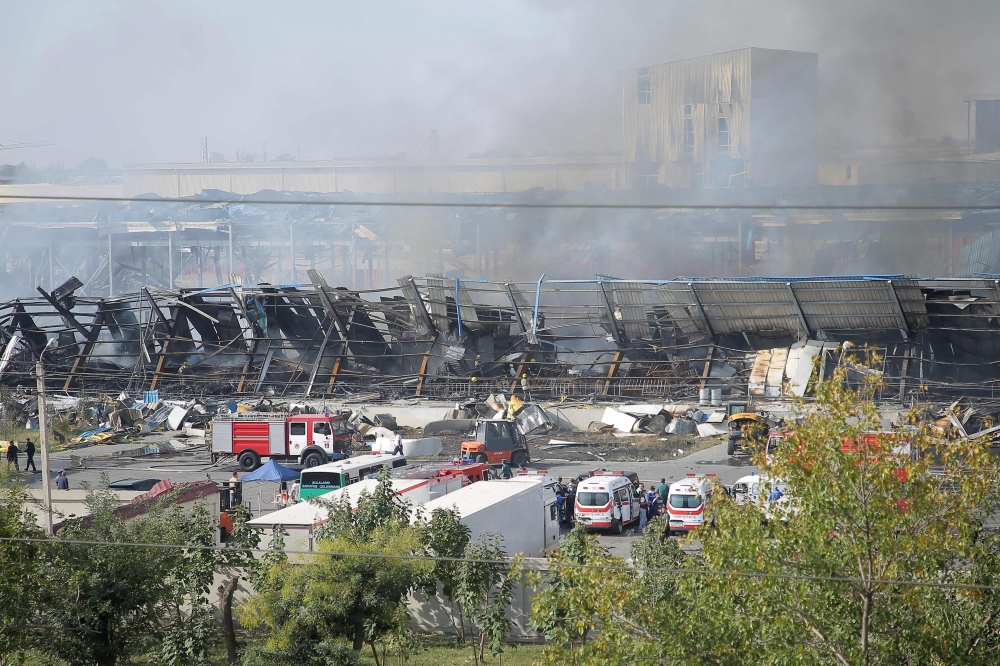 Rescuers work as smoke stills rising on September 28, 2023 at the site of an explosion at a warehouse near the airport in Tashkent that caused multiple injuries (Photo by Temur Ismailov / AFP)
