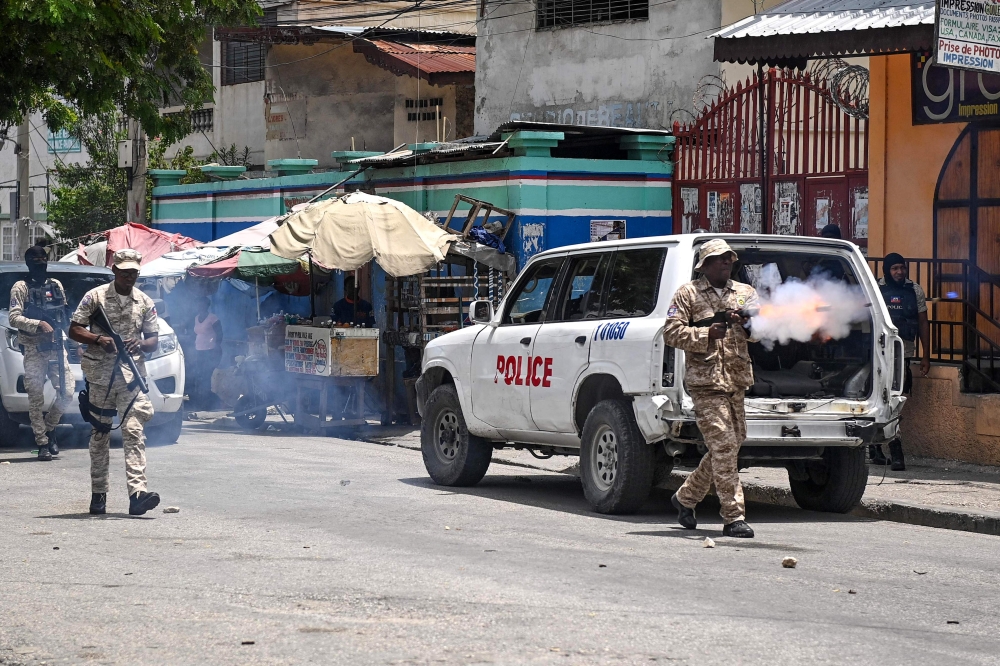 Police officers throw tear gas to demonstrators during a protest against insecurity in Carrefour-Feuilles, a district of Port-au-Prince, Haiti, on August 14, 2023. (Photo by Richard Pierrin / AFP)