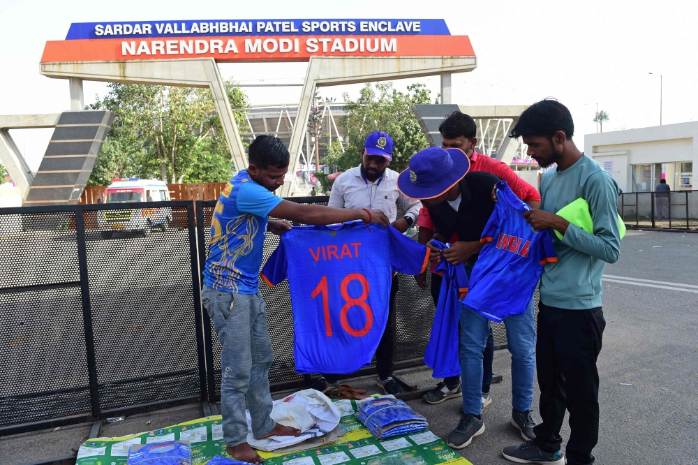 A vendor exhibits t-shirts to customers outside the Narendra Modi Stadium, ahead of the 2023 ICC men's cricket World Cup, in Ahmedabad on October 2, 2023.  (Photo by Sam Panthaky / AFP)
 