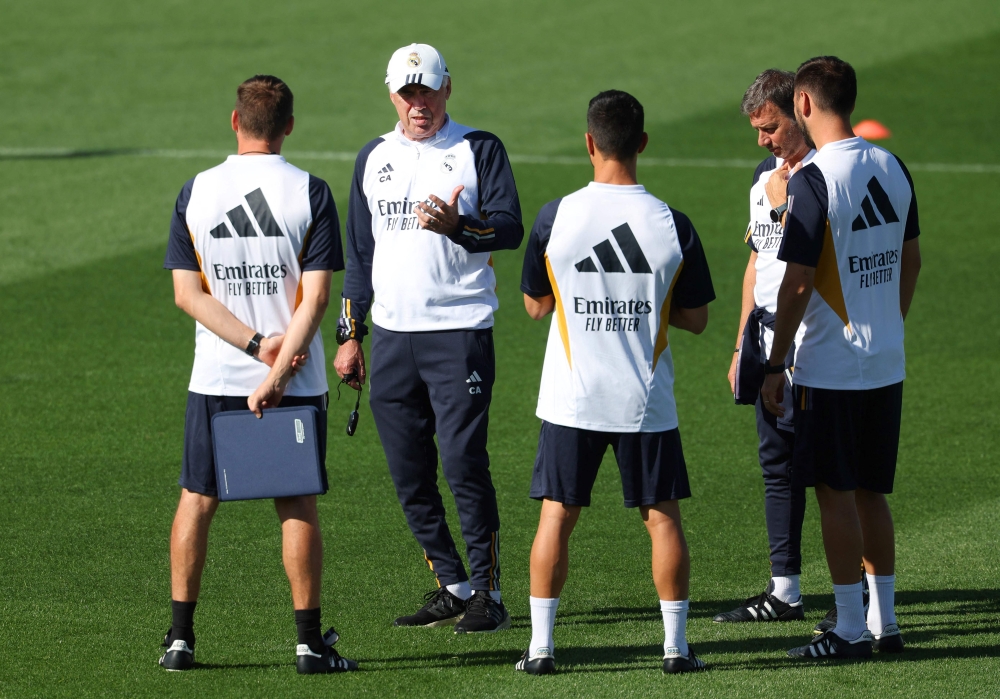 Real Madrid's Italian coach Carlo Ancelotti (2nd left) chats with his staff during a training session at Valdebebas Sport City in Madrid on October 6, 2023. (Photo by PIERRE-PHILIPPE MARCOU / AFP)