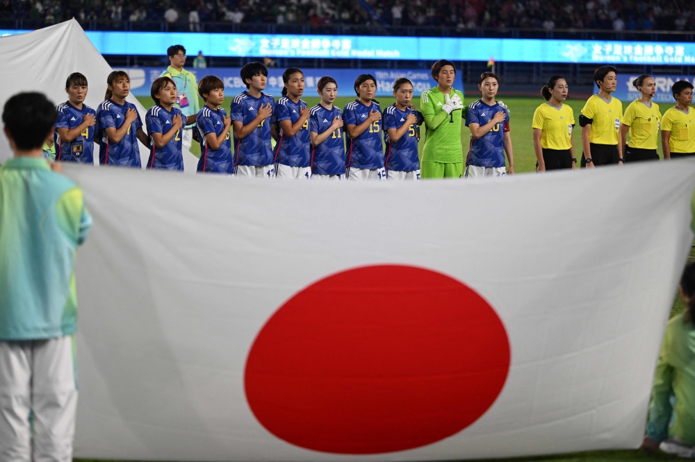 Japan's players sing the national anthem prior to the women's football gold medal match between Japan and North Korea during the 2022 Asian Games in Hangzhou in China's eastern Zhejiang province on October 6, 2023. (Photo by JUNG YEON-JE / AFP)