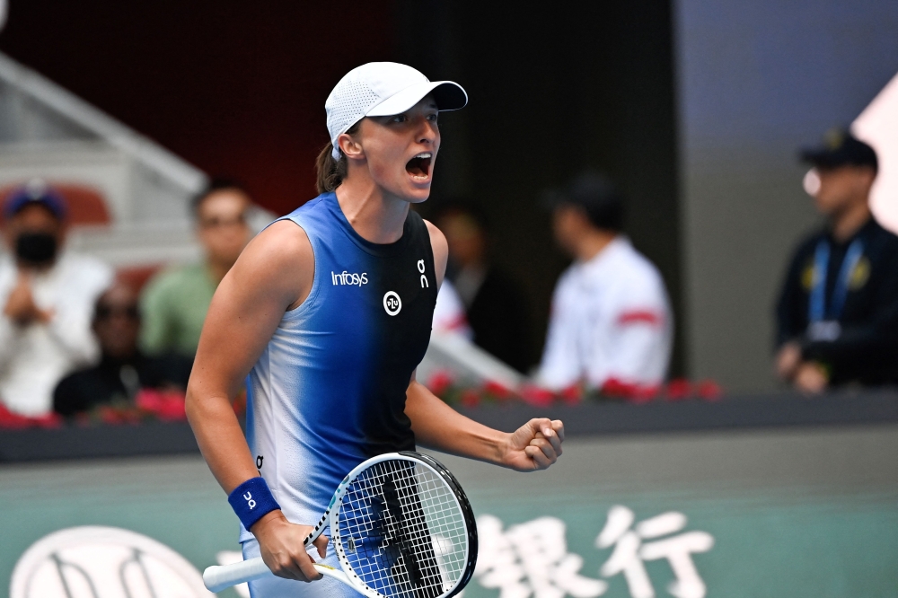 Poland's Iga Swiatek celebrates after beating USA's Coco Gauff during their women’s singles semi-final match of the WTA China Open tennis tournament in Beijing on October 7, 2023. (Photo by Pedro Pardo / AFP)