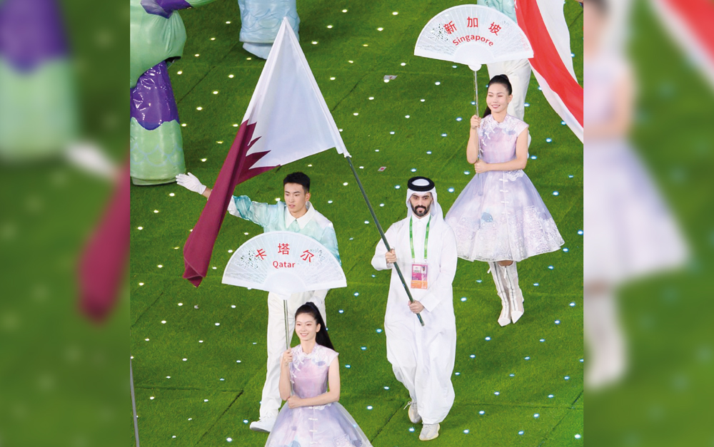 A Qatari athlete carries the national flag during the closing ceremony of the 2022 Asian Games at the Hangzhou Olympic Sports Centre Stadium in Hangzhou, yesterday.