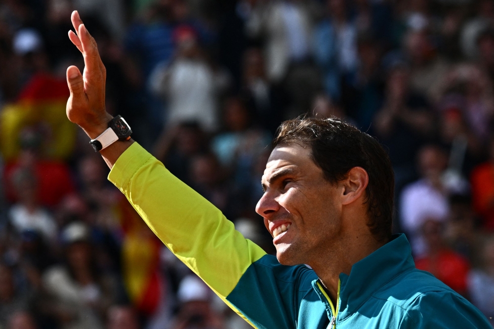 Spain's Rafael Nadal waves as he celebrates after victory over Norway's Casper Ruud during their men's singles final match on day fifteen of the Roland-Garros Open tennis tournament at the Court Philippe-Chatrier in Paris on June 5, 2022. Photo by Anne-Christine POUJOULAT / AFP