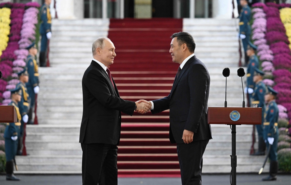 This pool photograph distributed by Russian state owned agency Sputnik shows Russia's President Vladimir Putin and his Kyrgyz counterpart Sadyr Japarov attending a ceremony to mark the 20th anniversary the Kant Russian aviation military base in Kyrgyzstan, at the Ala-Archa state residence in Bishkek on October 12, 2023. (Photo by Pavel Bednyakov / POOL / AFP)
