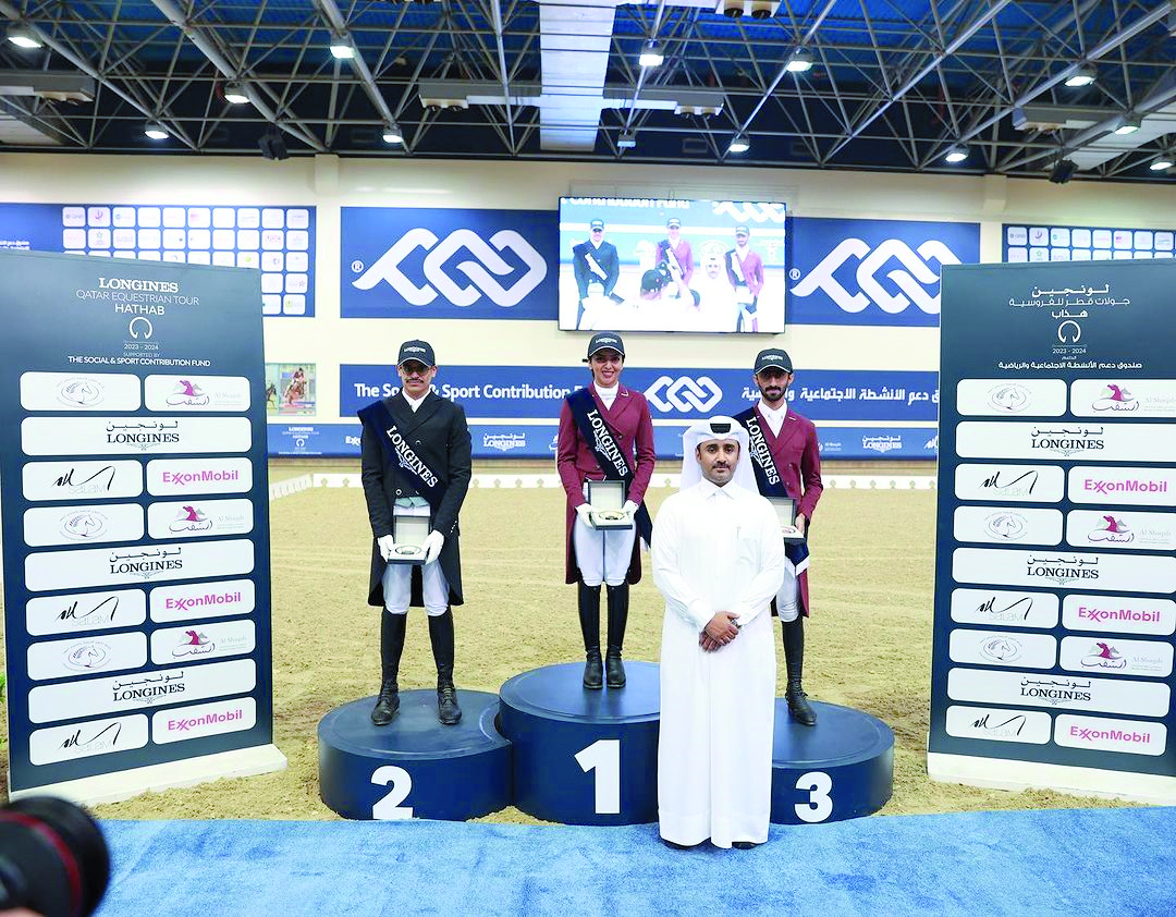 Maryam Ahmed Alsemaitt (centre) poses on the podium along with Saoud Ahmed Al Boinin (left) and Al Jaham Al Kuwari yesterday