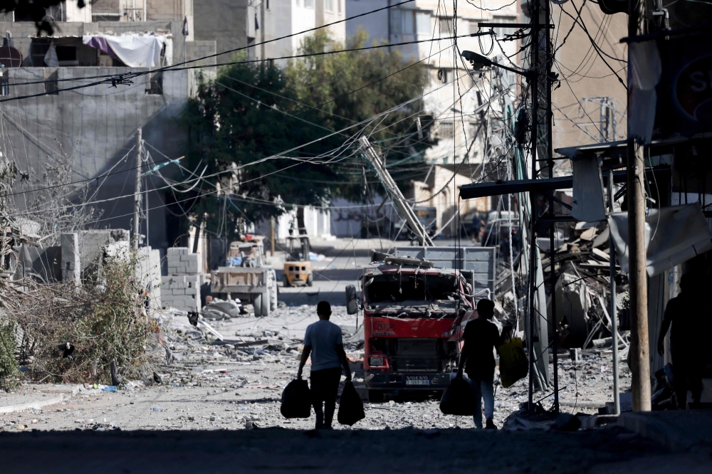 Palestinians with their belongings flee to safer areas in Gaza City after Israeli air strikes, on October 13, 2023. Photo by MOHAMMED ABED / AFP
