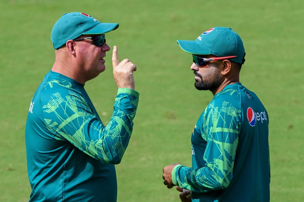 Pakistan's captain Babar Azam (R) talks with team director Mickey Arthur during a practice session on the eve of the 2023 ICC Men's Cricket World Cup one-day international (ODI) match between India and Pakistan at the Narendra Modi Stadium in Ahmedabad on October 13, 2023. (Photo by Punit PARANJPE / AFP)