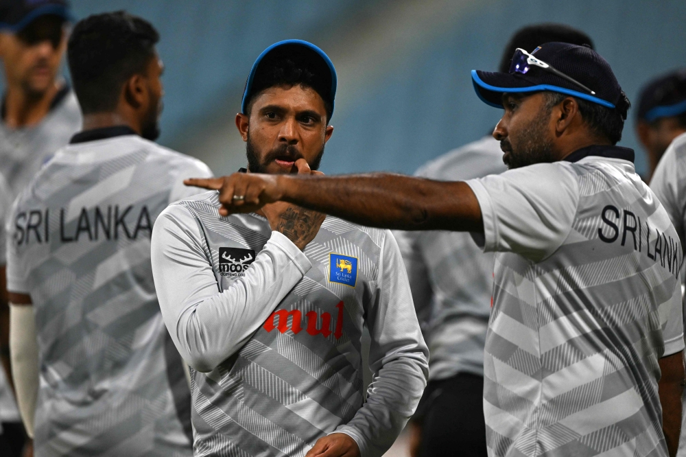 Sri Lanka's Kusal Mendis (centre) listens to his team consultant Mahela Jayawardene (right) during a practice session on the eve of their 2023 ICC Men's Cricket World Cup one-day international (ODI) match against Australia at the Ekana Cricket Stadium in Lucknow on October 15, 2023. (Photo by Arun Sankar / AFP)