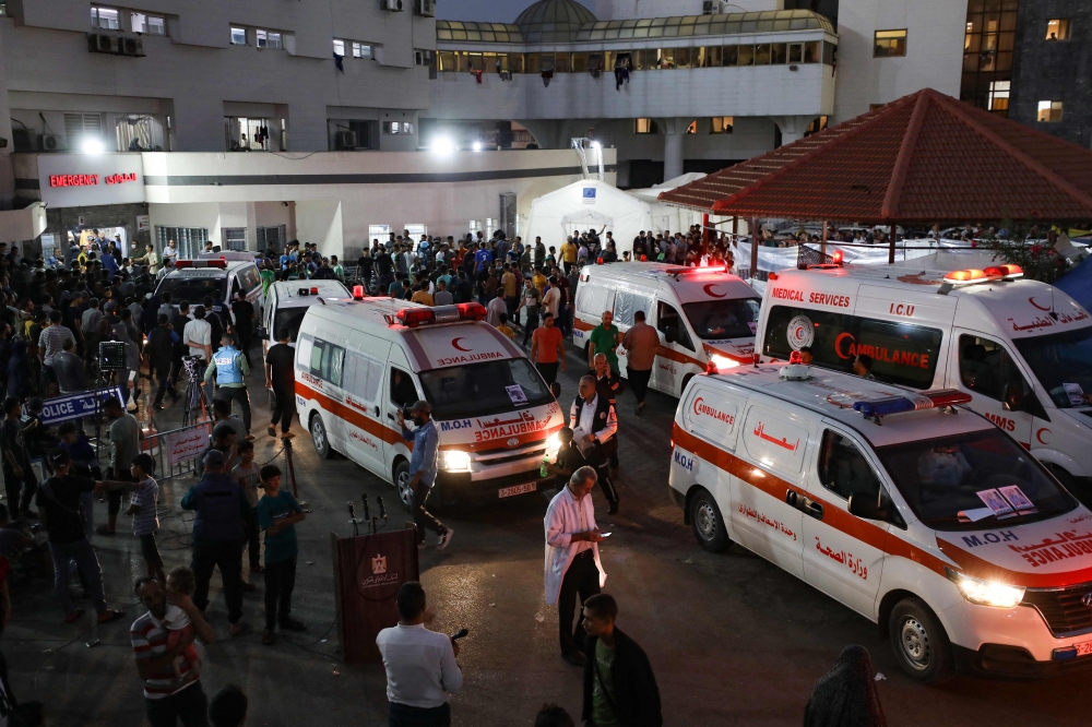 Ambulances carrying victims of Israeli strikes crowd the entrance to the emergency ward of the Al-Shifa hospital in Gaza City on October 15, 2023. (Photo by Dawood NEMER / AFP)
