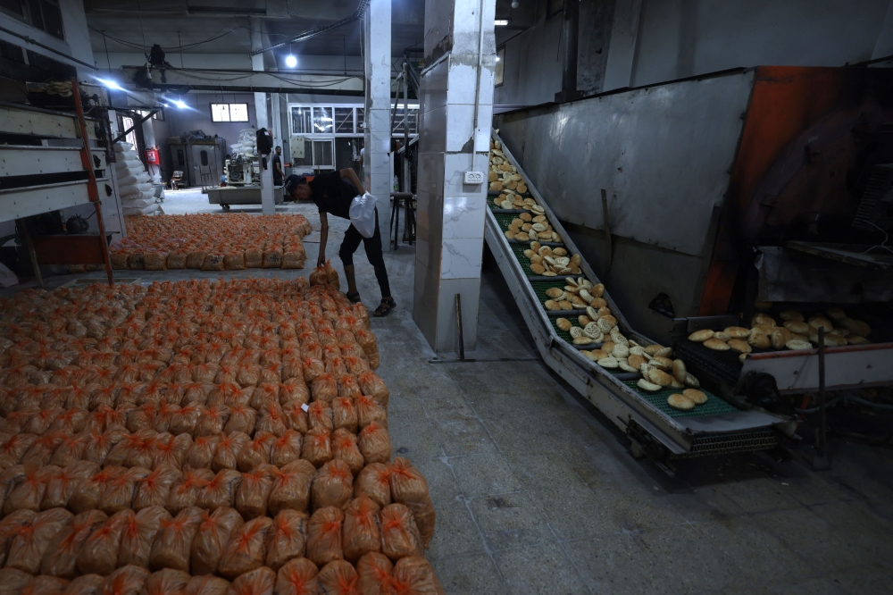 A bakery prepares rations of bread to pass out to internally displaced Palestinians in the Rafah refugee camp, in the southern Gaza Strip on October 17, 2023. (Photo by Mohammed Abed / AFP)
 