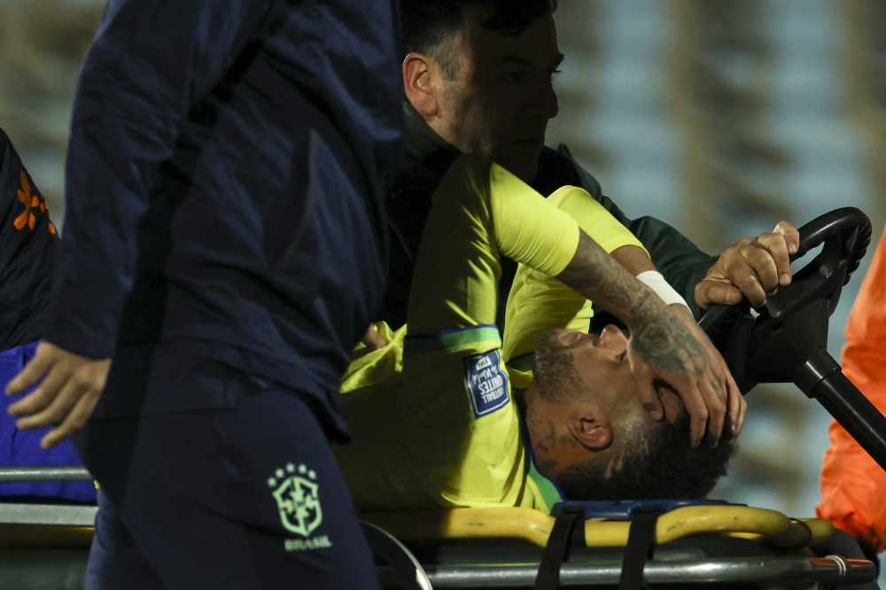 Brazil's forward Neymar leaves the field crying in pain after an injury on October 17, 2023. (Photo by Pablo PORCIUNCULA / AFP)