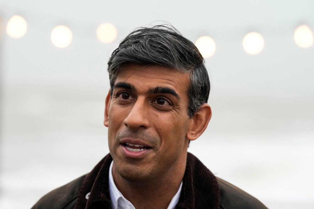 Britain's Prime Minister Rishi Sunak speaks to a TV reporter during a visit to Clacton-on-Sea, south east England, on October 18, 2023. (Photo by Frank Augstein / POOL / AFP)