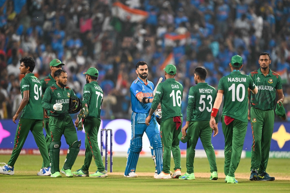 Bangladesh's players greet India's Virat Kohli (C) after India won the 2023 ICC Men's Cricket World Cup one-day international (ODI) match against Bangladesh at the Maharashtra Cricket Association Stadium in Pune on October 19, 2023. (Photo by Punit PARANJPE / AFP)