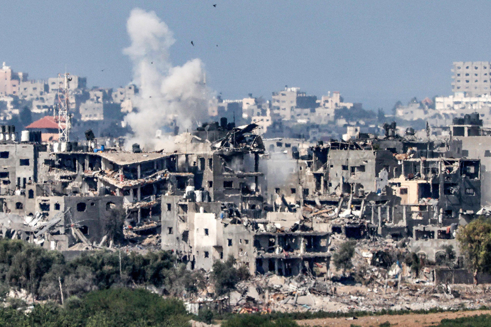 Smoke rises above buildings destroyed by Israeli bombardment in Gaza yesterday. (AFP)