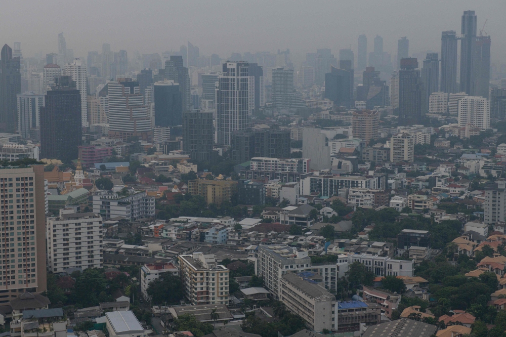 The city skyline is pictured amid high levels of air pollution in Bangkok on October 18, 2023. Photo by Alex OGLE / AFP