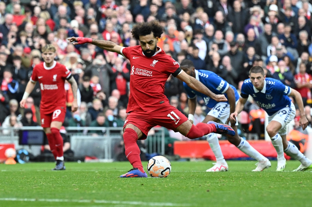 Liverpool's Egyptian striker #11 Mohamed Salah scores the opening goal from the penalty spot during the English Premier League football match between Liverpool and Everton at Anfield in Liverpool, north west England on October 21, 2023. (Photo by Paul ELLIS / AFP) 