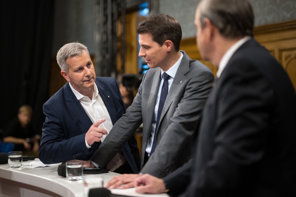 Swiss People's Party (SVP UDC) leader Marco Chiesa (L) speaks with the President of the FDP Liberals Swiss political party Thierry Burkart (C) and the President of The Centre (Die Mitte) Swiss political party Gerhard Pfister (R) prior a TV interview during Swiss federal elections to elect a new Parliament, in Bern on October 22, 2023. (Photo by Fabrice COFFRINI / AFP)
