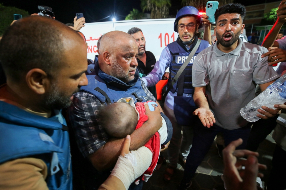 Al-Jazeera correspondent Wael Al-Dahdouh mourns over the body of one of his children in the Nuseirat camp, at Al-Aqsa hospital in Deir Al-Balah on the southern Gaza Strip, on Ocober 25, 2023. (Photo by Majdi FATHI / AFP)