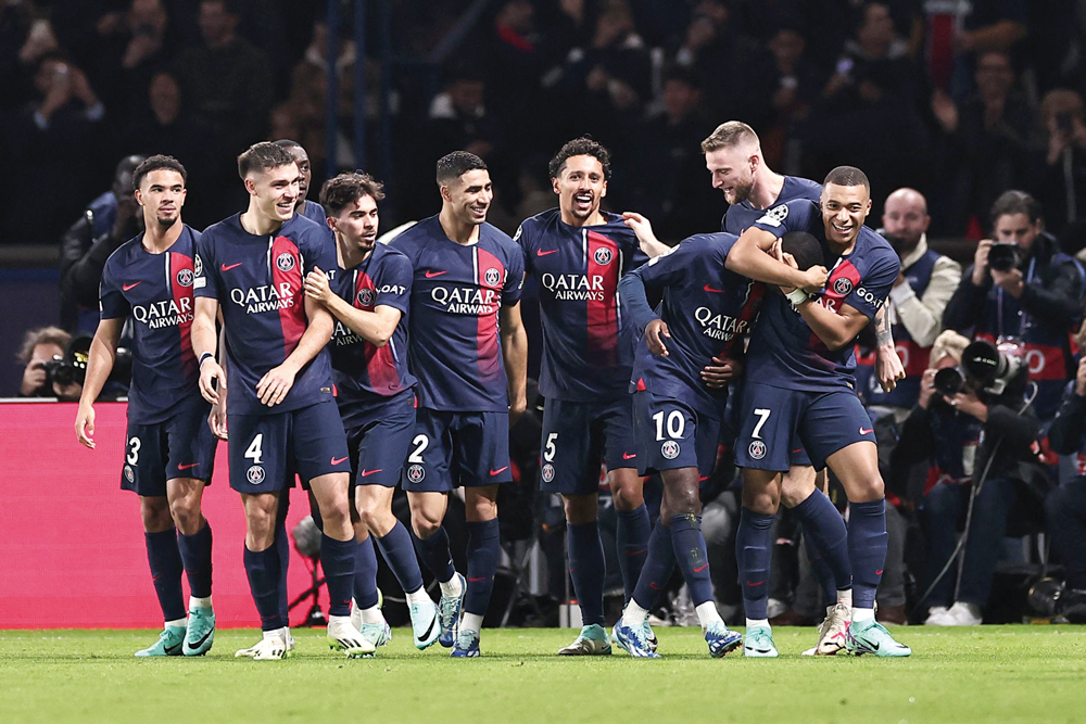 PSG’s players celebrate during the UEFA Champions League Group F match against AC Milan, in Paris, yesterday. AFP