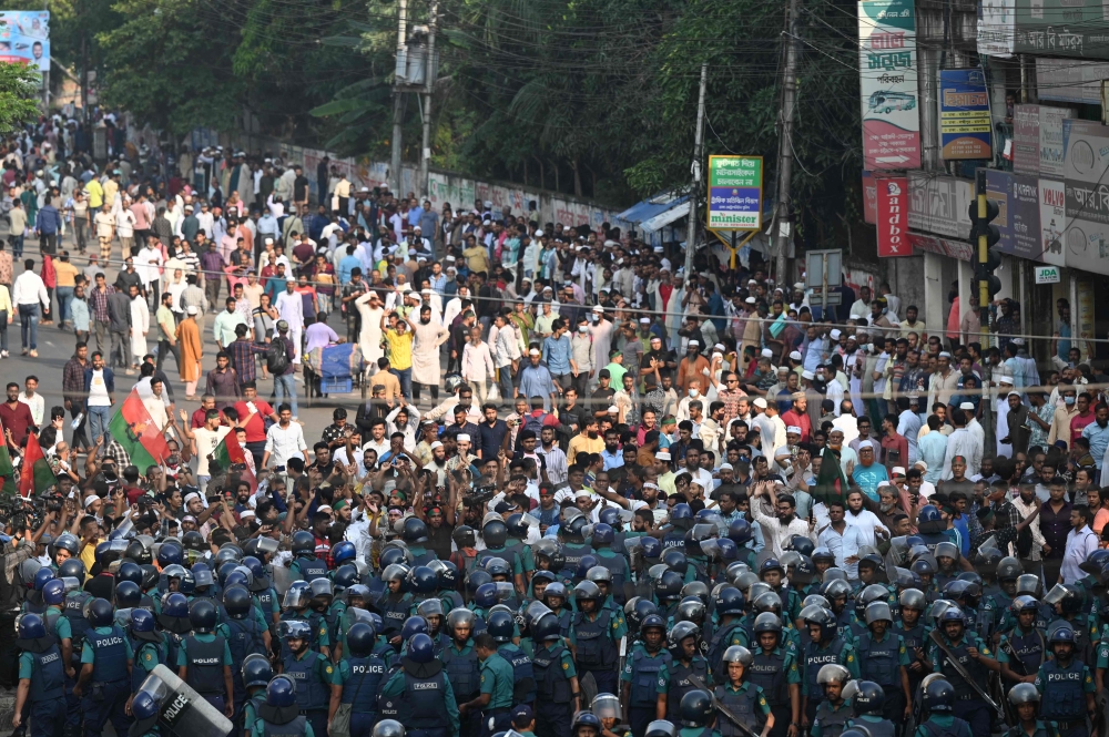 Police (front) stand guard in front of Bangladesh Nationalist party (BNP) activists in Dhaka on October 28, 2023. (Photo by Munir uz ZAMAN / AFP)