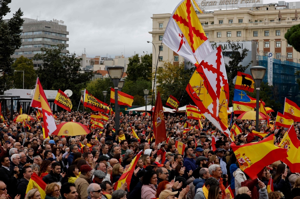 Protestors wave Spanish national flags as they take part in a demonstration called by the Spanish far-right Vox party against plans to grant amnesty to Catalan separatists, in Madrid on October 29, 2023. (Photo by Oscar Del Pozo / AFP)