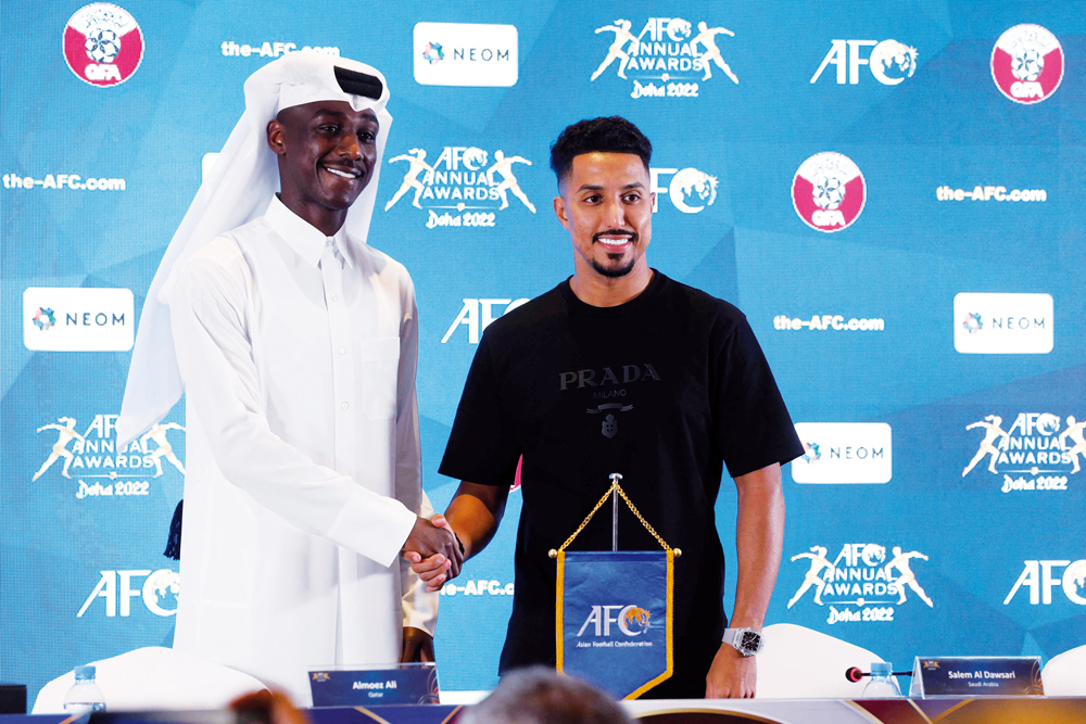 Qatar’s Almoez Ali (left) and Saudi Arabia’s Salem Al Dawsari shake hands during a press conference on the eve of the AFC Annual Awards Doha 2022, yesterday. AFP