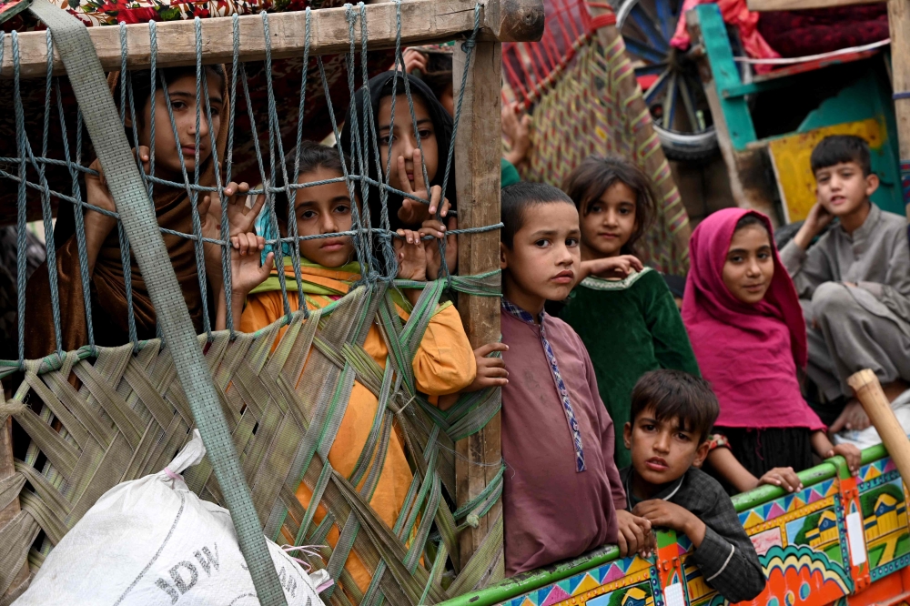 Afghan children refugees arrive on trucks from Pakistan at the Afghanistan-Pakistan Torkham border in Nangarhar province on November 1, 2023. (Photo by Wakil KOHSAR / AFP)
