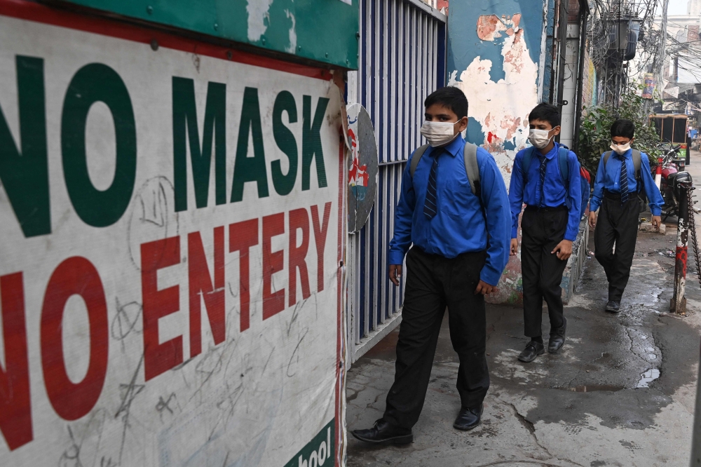 Students wearing facemasks arrive at a school in Lahore on November 2, 2023, following Punjab's government announcement to use facemasks due to severe smoggy conditions. (Photo by Arif Ali / AFP)