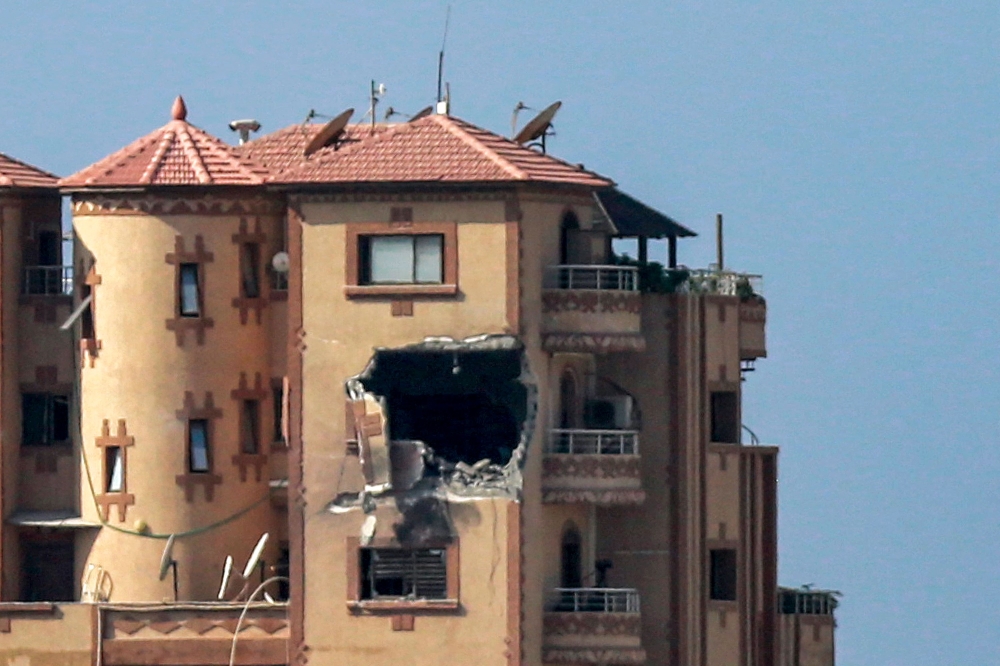 This picture taken on November 3, 2023 shows a gaping hole following a strike on the Hajji building, which houses several offices including those of Agence France Presse (AFP) in Gaza City. (Photo by Bashar TALEB / AFP) 
