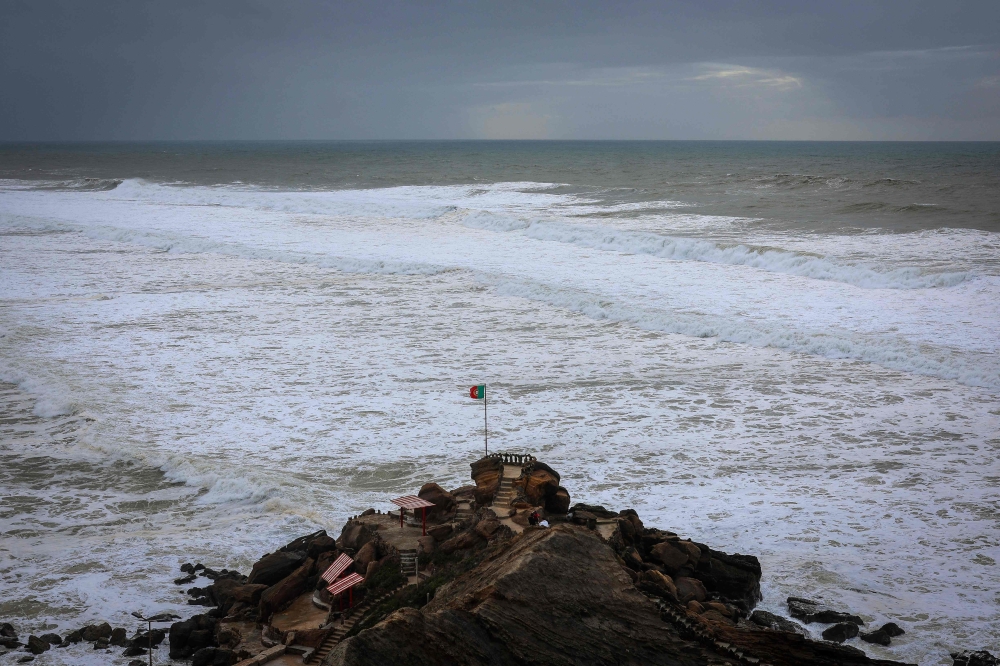 A Portuguese flag flies at Formosa beach, in the municipality of Torres Vedras during the Ciaran storm on November 3, 2023. (Photo by Patricia De Melo Moreira / AFP)