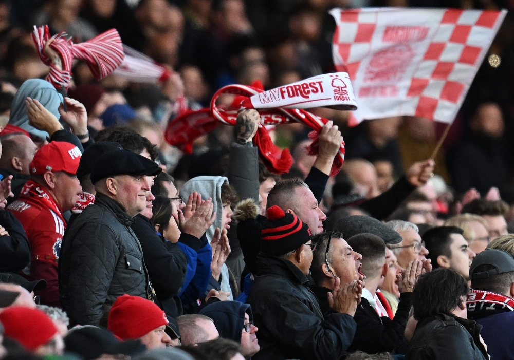 Forrest fans cheers their team during the English Premier League football match between Nottingham Forest and Aston Villa at The City Ground in Nottingham, central England, on November 5, 2023. (Photo by Paul ELLIS / AFP)