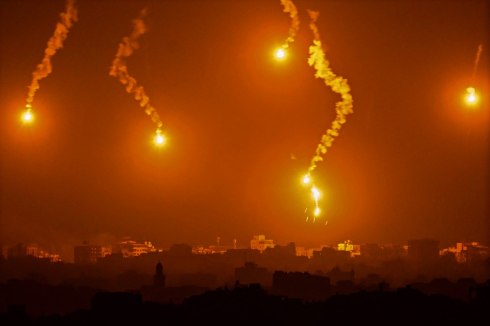 This picture taken from a position near Sderot along the Israeli border with the Gaza Strip on November 5, 2023, shows flares dropped by Israeli forces above the Palestinian enclave. (Photo by Aris Messinis / AFP)