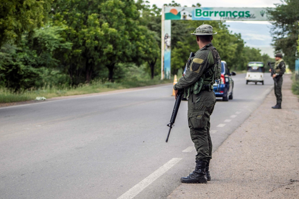 Colombian Army members stand guard at a checkpoint in Barrancas, La Guajira, Colombia on November 6, 2023. (Photo by Lismari Machado / AFP)
