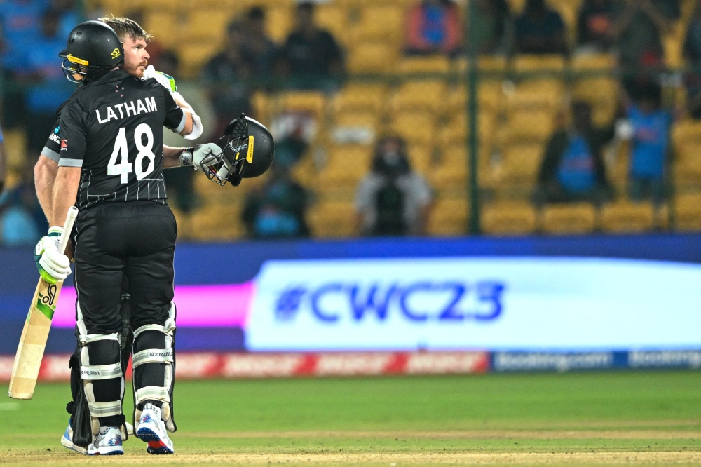New Zealand's Tom Latham (L) and Glenn Phillips celebrate their win at the end of the 2023 ICC Men's Cricket World Cup one-day international (ODI) match against Sri Lanka at the M. Chinnaswamy Stadium in Bengaluru on November 9, 2023. (Photo by R.Satish BABU / AFP) 