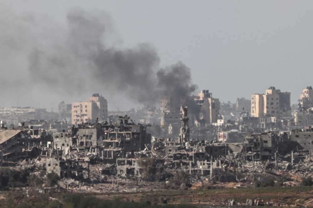Smoke billowing behind destroyed buildings in the Palestinian enclave during an Israeli strike on November 10, 2023. (Photo by Jack Guez / AFP)
