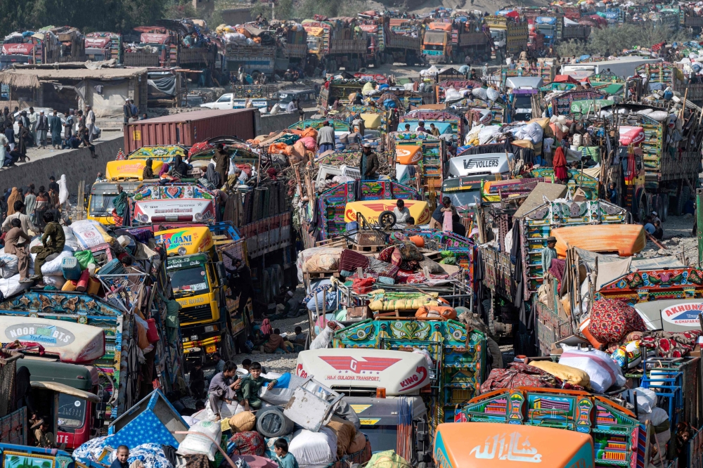 In this file photo, Afghan refugees arrive in trucks from Pakistan at the Afghanistan-Pakistan Torkham border in Nangarhar province on October 30, 2023. (Photo by Wakil Kohsar / AFP)