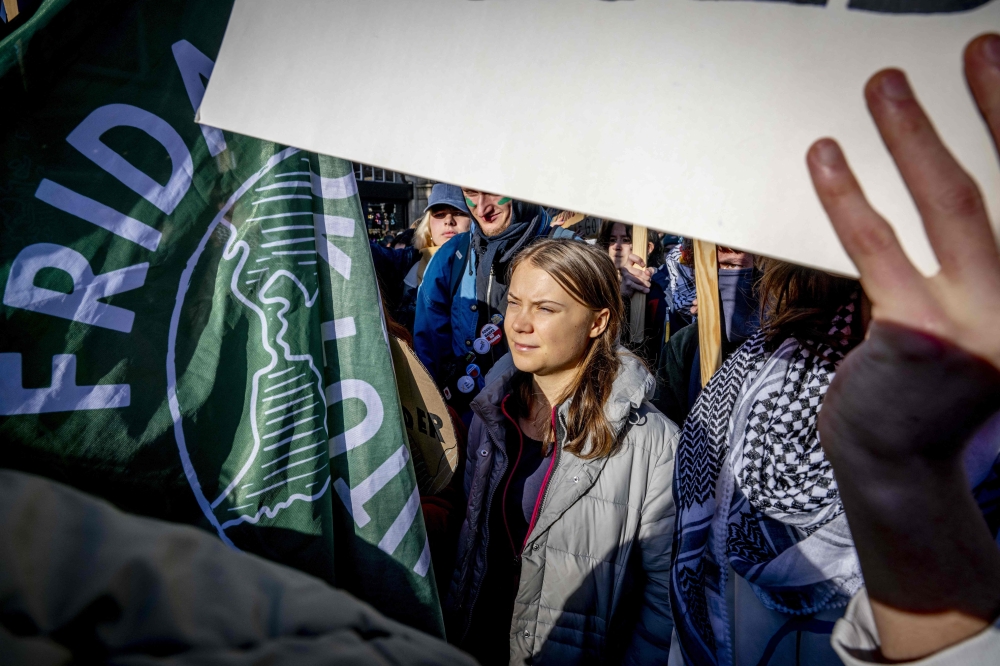 Swedish climate activist Greta Thunberg marches with climate activists during a rally for climate and justice, in Amsterdam, on November 12, 2023. (Photo by Robin Utrecht / ANP / AFP)