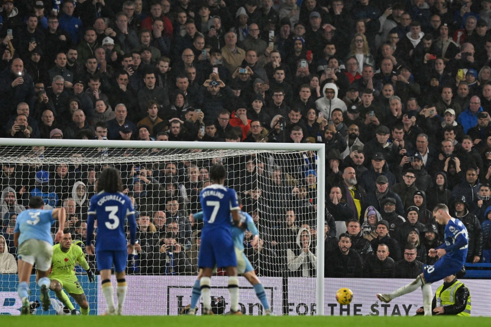 Manchester City's English midfielder #80 Cole Palmer (R) scores their fourth goal from the penalty spot during the English Premier League football match between Chelsea and Manchester City at Stamford Bridge in London on November 12, 2023. (Photo by Glyn KIRK / IKIMAGES / AFP) 

