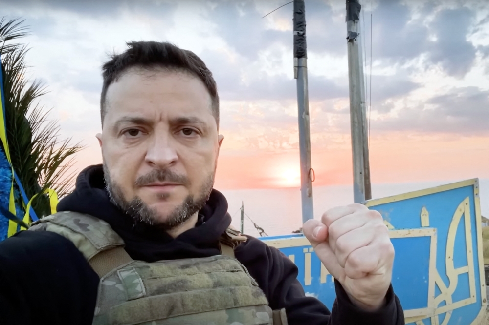 File: In this handout video grab taken from footage released by the Ukrainian Presidency on July 8, 2023, Ukraine's President Volodymyr Zelensky pumps his fist as he visits the Snake Island (Zmiinyi Island), Odesa region.