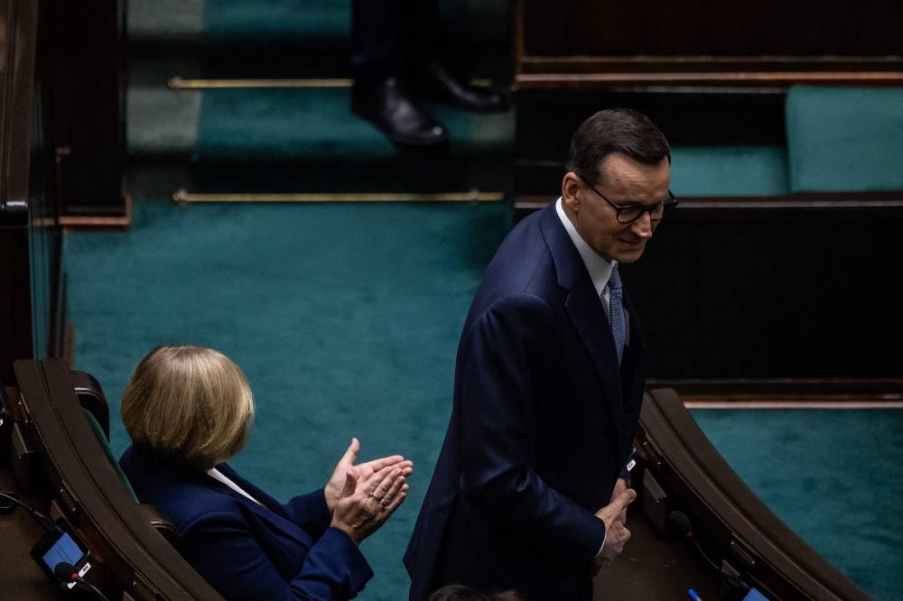 Polish Prime Minister Mateusz Morawiecki (R) attends a session as Poland's new parliament meets for the first time with both the ruling populists and the pro-European opposition bidding to form the next government, on November 13, 2023 in Warsaw. (Photo by Wojtek Radwanski / AFP)
