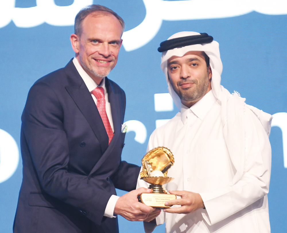 Chairman of Qatar Tourism Saad bin Ali Al Kharji giving award to General Manager of Hilton Salwa Beach Resort & Villas Etienne Gailliez.